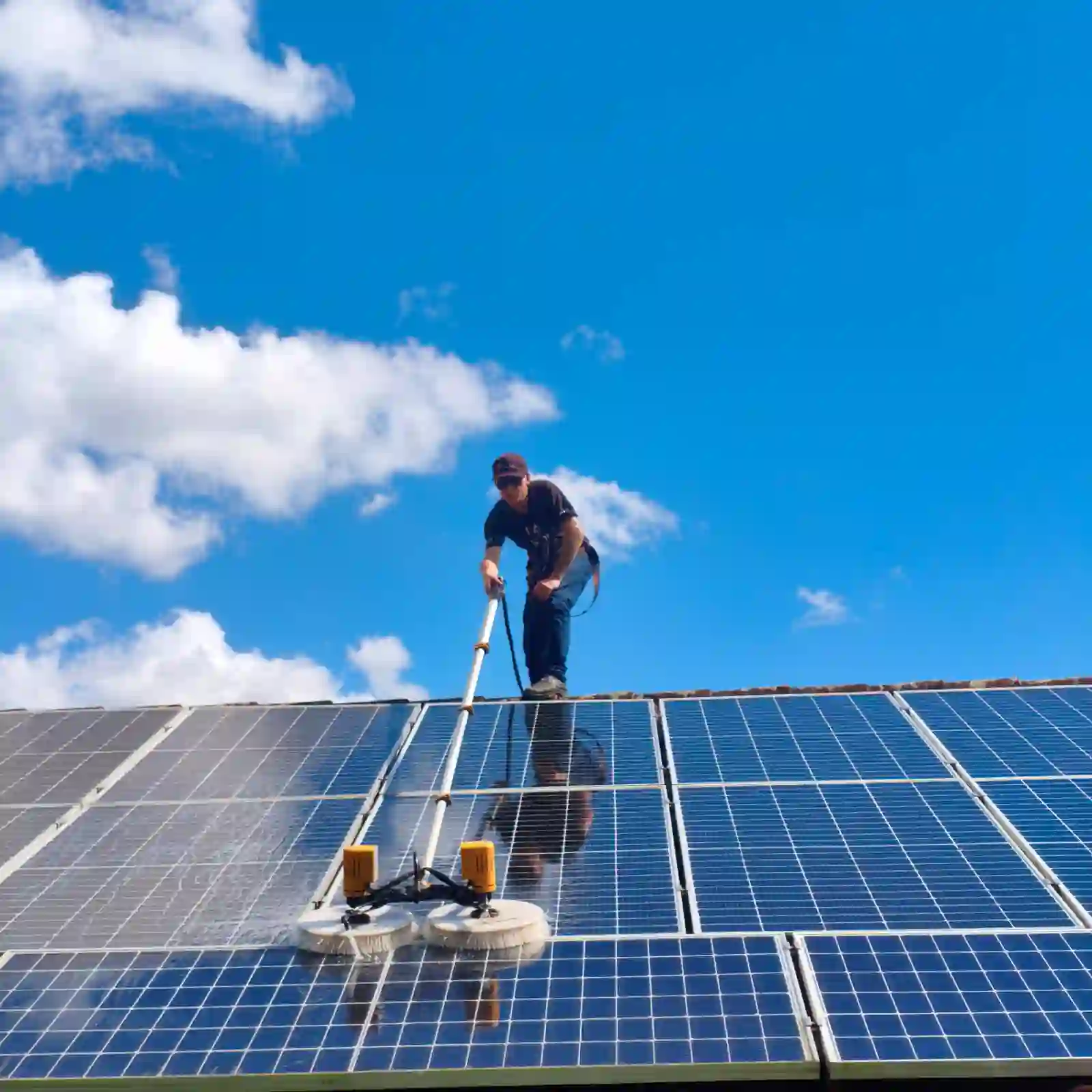 Técnico limpando painéis solares sujos com equipamento apropriado
